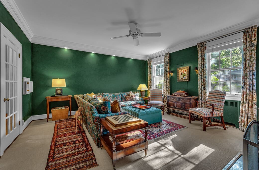 Luxurious living room with green walls, ornate sofa, and antique furniture