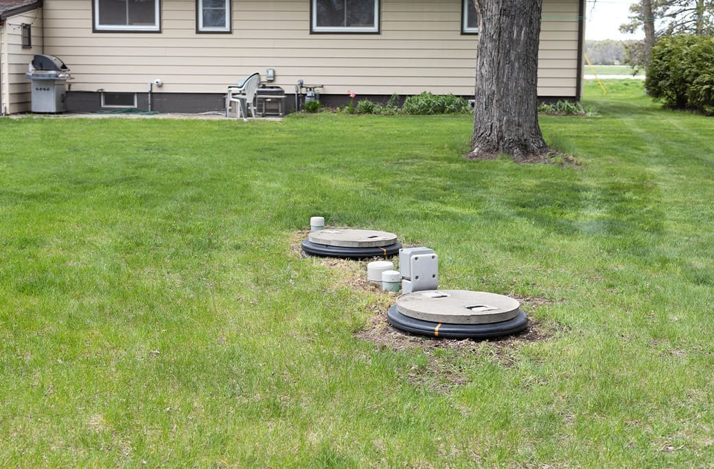 Septic tank access risers in a grassy yard, a potential Winston-Salem home buying risk.