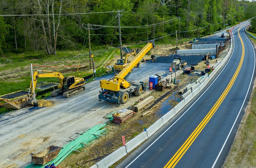 Road construction near a residential neighborhood expanding a two lane road