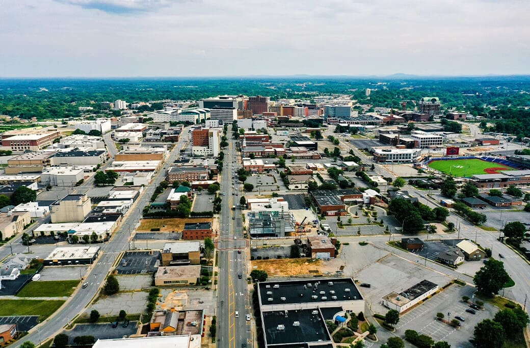 Aerial view of downtown High Point, NC, showing city streets, buildings, and a baseball stadium.